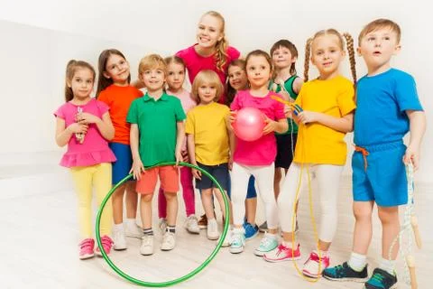 Portrait of happy sports teacher and kids at gym Stock Photos