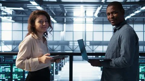 Portrait of happy system administrators in data center using devices 写真素材