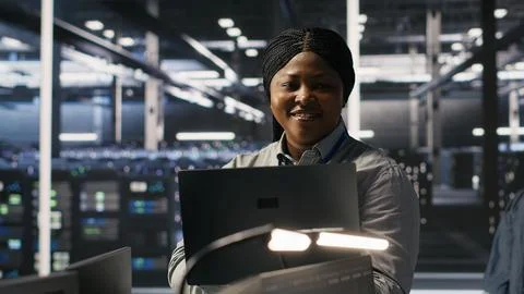 Portrait of happy technician next to data center colleagues review AI systems 写真素材