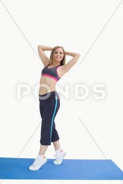 Portrait of happy woman posing on exercise mat Stock Photos