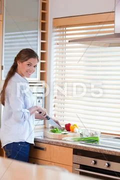 Portrait of a happy woman slicing pepper Stock-Fotos