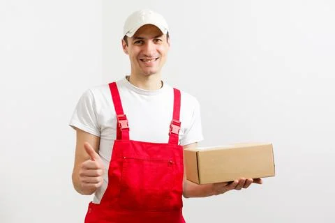Portrait of happy worker unloading boxes from a delivery van and looking at Stock Photos