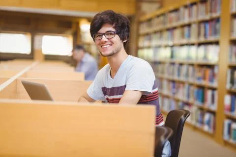 Portrait of happy young student using his laptop 写真素材