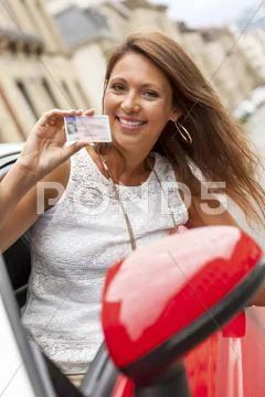 Portrait Of Happy Young Woman Presenting Her Driving License
