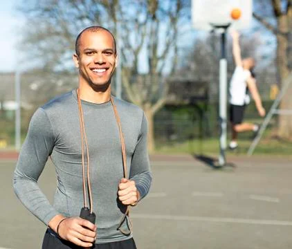 Portrait of a healthy attractive man holding a skipping rope and smiling Stock Photos