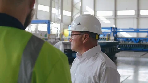 Portrait of heavy industry engineer talking to worker showing to renovated Stock Footage 120692699