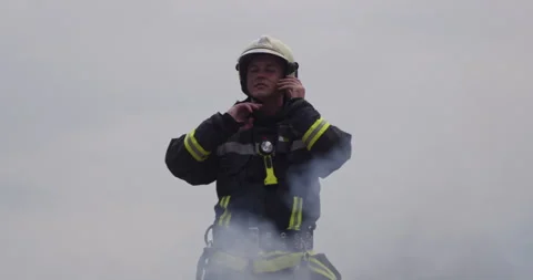 Portrait of a heroic fireman in a protective suit. Firefighter in fire fighting Stock Footage 283080489