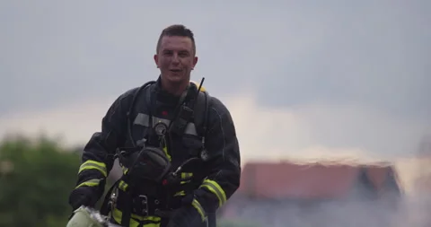 Portrait of a heroic fireman in a protective suit. Firefighter in fire fighting Stock Footage 283088636