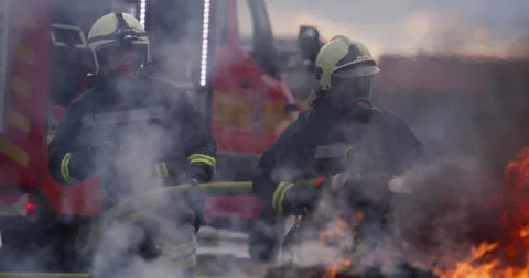 Portrait of a heroic fireman in a protective suit. Firefighter in fire fighting Stock Footage 283090575