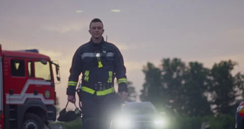 Portrait of a heroic fireman in a protective suit. Firefighter in fire fighting Stock Footage 283093754