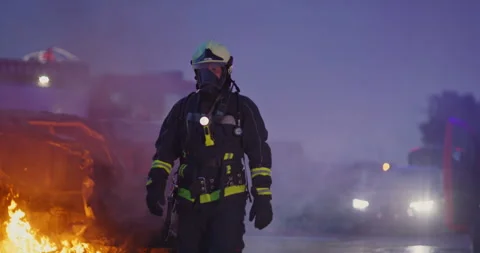 Portrait of a heroic fireman in a protective suit. Firefighter in fire fighting Stock Footage 283095327