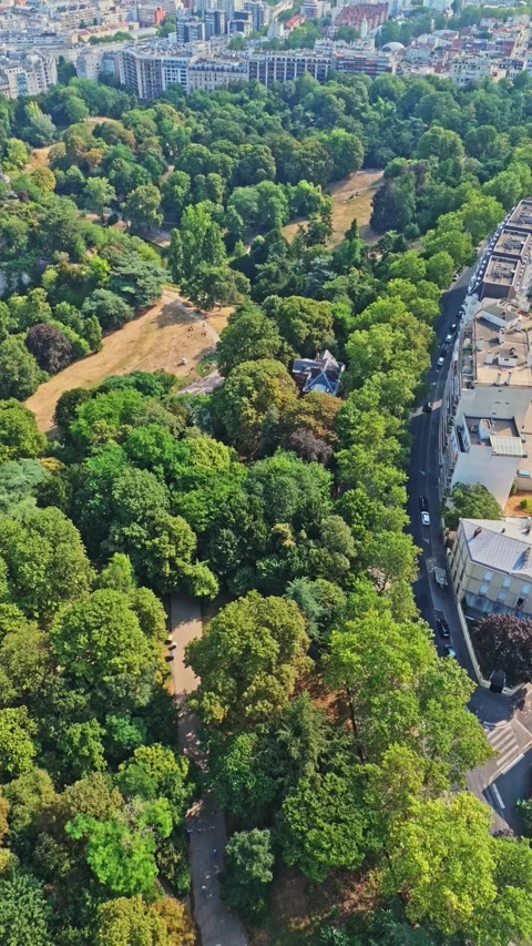 Portrait high angle drone shot over the Parc des buttes chaumont in Paris city Stock-Footage 341075081