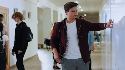 Portrait of high school student putting his backpack in a locker. Two friends Stock Footage 113626791