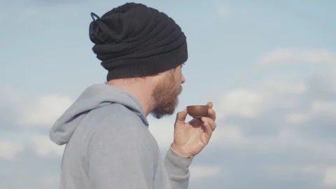 Portrait of hipster with a beard drinking tea from a bowl outdoors. tea ceremony Stock Footage 119336551