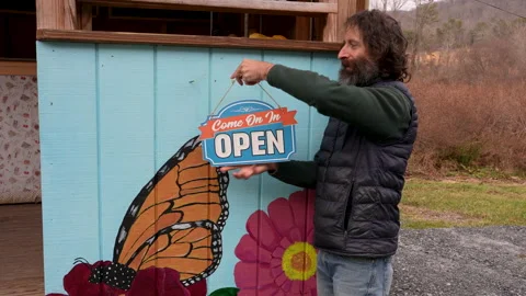 Portrait of a hipster with a beard opening his business Stock Footage 146807426