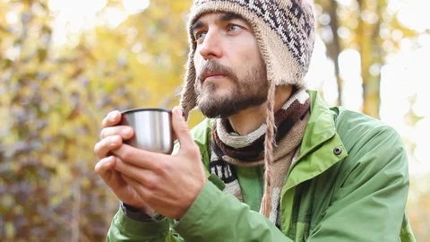 Portrait hipster millennial warms hands with cup of hot tea or coffee, autumn Видео 103239208