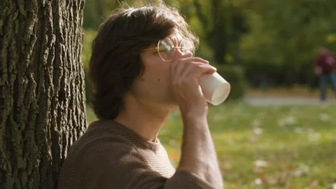 Portrait of hipster sitting on the grass Stock Footage 142457518