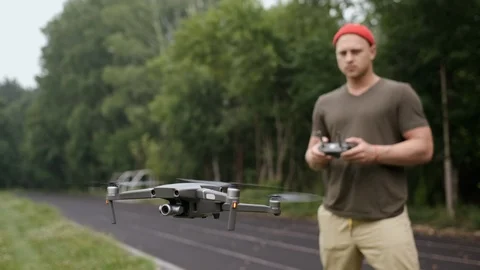 Portrait of a hipster using smartphone to control the quadcopter. Stock Footage 113010596