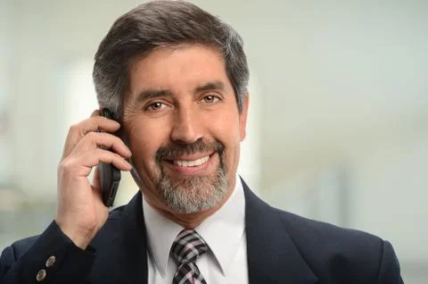 Portrait of hispanic businessman using cell phone Stock Photos
