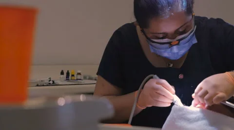 Portrait of a hispanic dentist cleaning a man's teeth - dolly shot Stock Footage 63210183