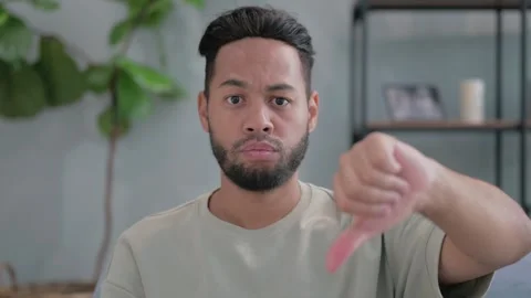 Portrait of Hispanic Man with Thumbs Down at Home Stockbeeldmateriaal 293258822