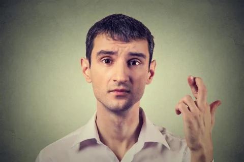 Portrait hopeful handsome man crossing his fingers hoping, asking best Stock Photos
