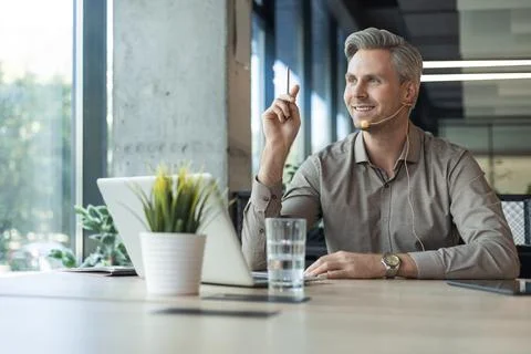 Portrait of hot line support operator at call center wearing headphones  Stock Photos