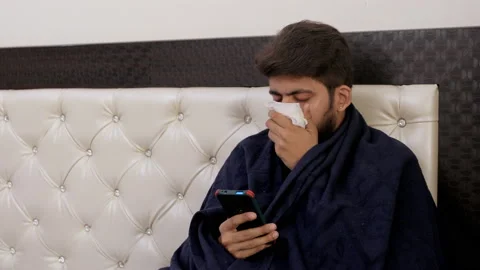Portrait of an Indian guy suffering from cold - common symptoms of Covid-19 Video stock 133223962