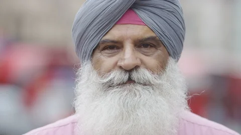 Portrait of Indian man in a turban smiling to camera, in slow motion Stock Footage