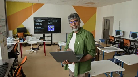 Portrait of Indian Middle Aged Man Holding Laptop in Computer Lab Stock Footage 342820729