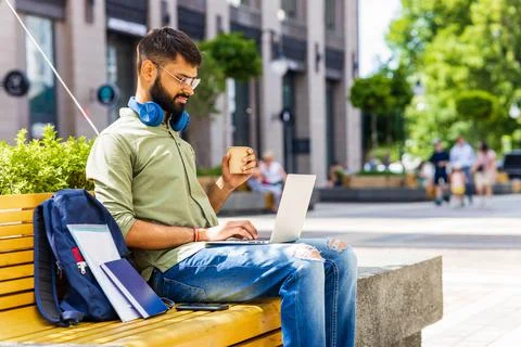 Portrait Indian student programmer using laptop computer in park Stock Photos