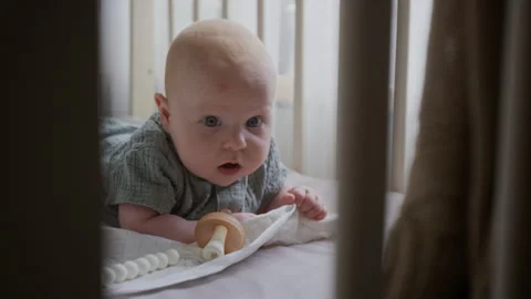 Portrait of Infant Doing Tummy Time in Crib Looking at Camera Vídeos de archivo 346594373