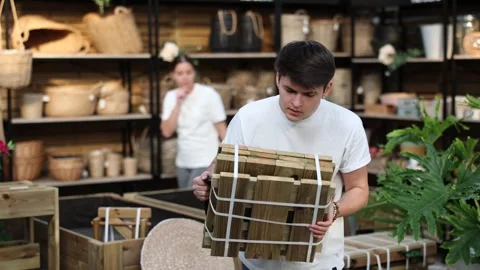 Portrait of interested young guy looking for functional folded wooden garden 動画素材 267645956