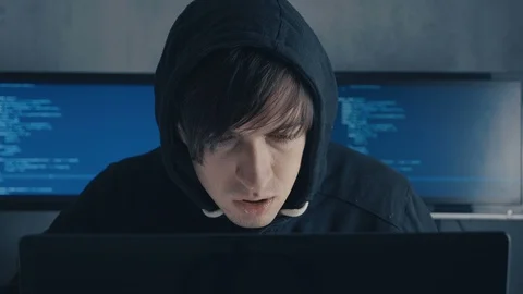 Portrait of IT professional hacker programmer in hood working on computer in Stock Footage 101263942