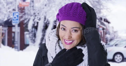 Portrait of joyful Latina female standing in snowy town, smiling at camera Stock Footage