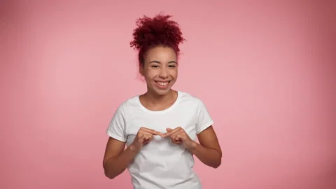 Portrait joyful smiling redhead African American woman draws heart shape in air Stock Footage 318220686