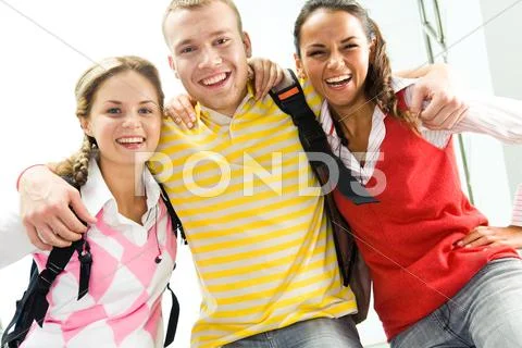 Portrait of joyful teens embracing and looking at camera with laugh Stock Photos