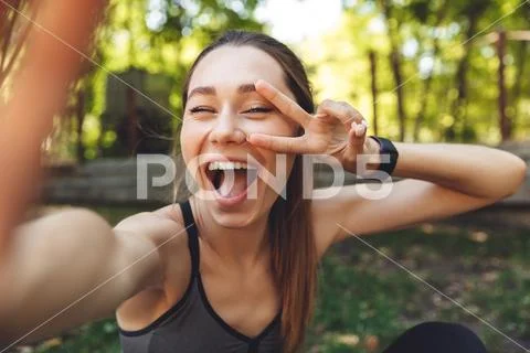 Portrait of a joyful young fitness girl taking a selfie Stock Photos