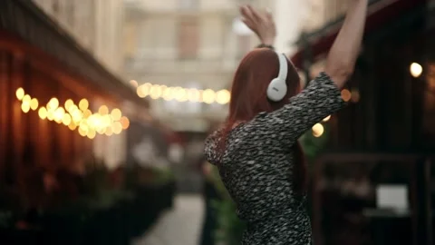 Portrait of joyful young red-haired woman listening to music in headphones Stock Footage 157927427