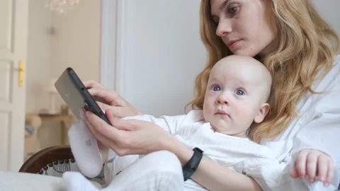 Portrait of a kid with mom looking at a tablet in a white apartment Video stock 140644524