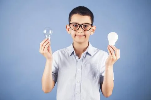Portrait of a kid using an energy-saving and incandescent lamp. Energy Stock Photos