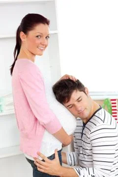 Portrait of an kind man with head on his pregnant woman's belly Stock Photos