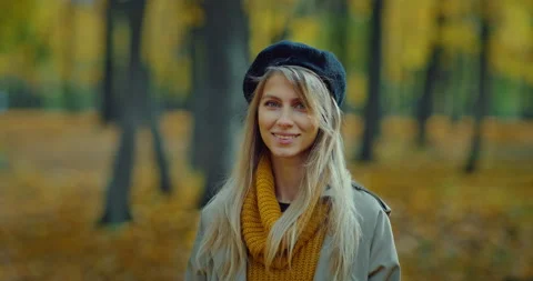 Portrait of lady looking at camera in beautiful park in autumn day, calm smile Stock Footage 230501018