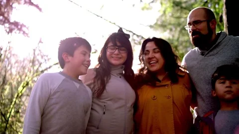 Portrait of a latin family smiling in a forest, lens flare Stock Footage