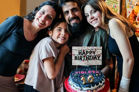Portrait of a Latino family celebrating little girl's 10th birthday Stock Photos