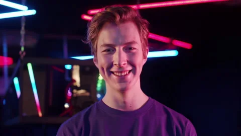 Portrait of a laughing young guy in a computer room in the light of neon lamps Stock Footage 151871187