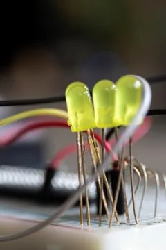 A portrait of LEDS wired into a breadboard creating an electronic circuit. Stock Photos