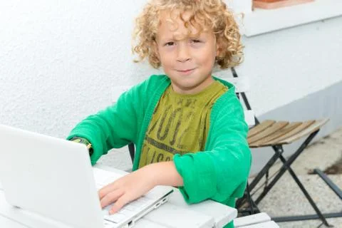 Portrait of a little blond boy using a laptop Fotos Stock