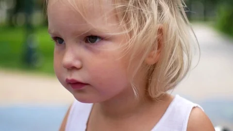 Portrait of a little blonde girl. Slow-motion shooting, the child laughs and loo Stock Footage