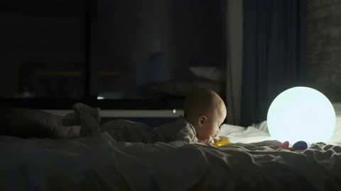 Portrait of a little boy on a bed in the light of a ball lamp 스톡 동영상 135422288